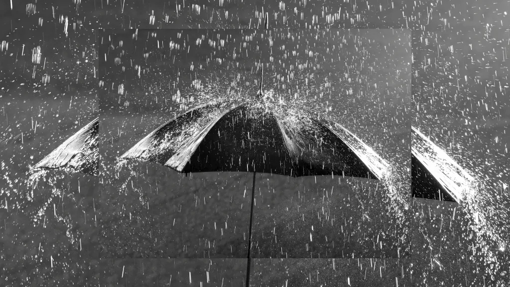 Guarda-chuva preto visto de cima sendo atingido por forte chuva, com gotas respingando ao redor, simbolizando proteção, limpeza emocional e o significado de sonhar com chuva.